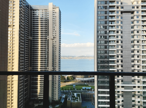 A cluster of contemporary high-rise buildings reaching upward under a broad sky.